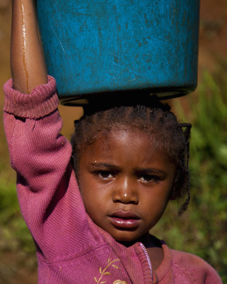 Girl carrying water bucket on her head