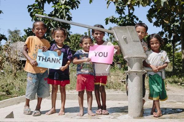 Children with pump and ‘Thank you’ signs, from left to right – Milcar Sacrmento De Araujo, 7; Marcia Da Costa, 5; Domingos De Araujo, 5; Juleita Ramos, 7; Ferdianus Da Costa, 7; Manuella Sarmento, 6.. Haliwain village, Manufahi district, Timor Leste.